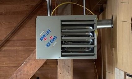 A heater is hanging from the ceiling of a building.