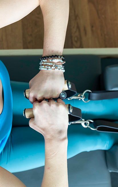 A woman is holding a pair of dumbbells in her hands.