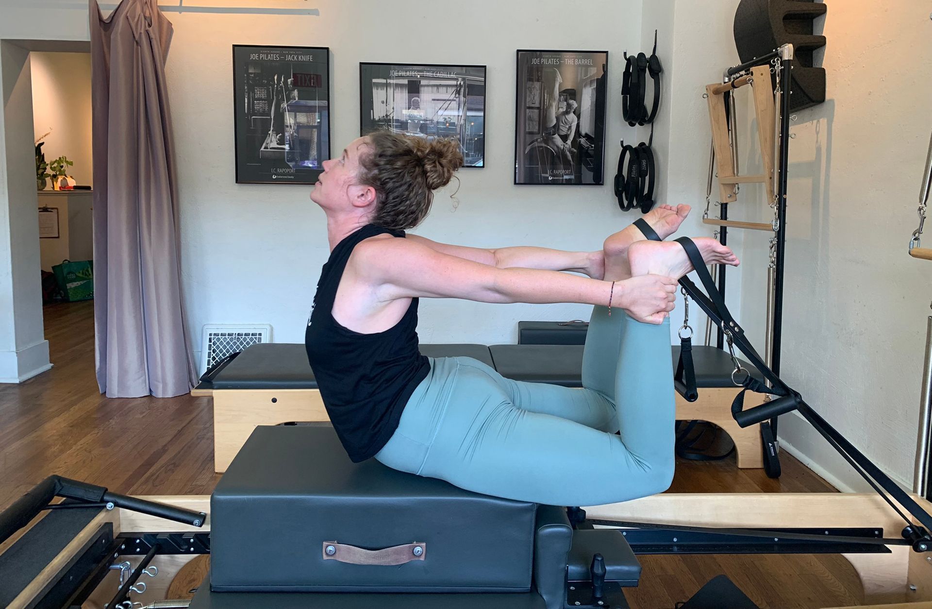 A woman is doing a yoga pose on a pilates machine.