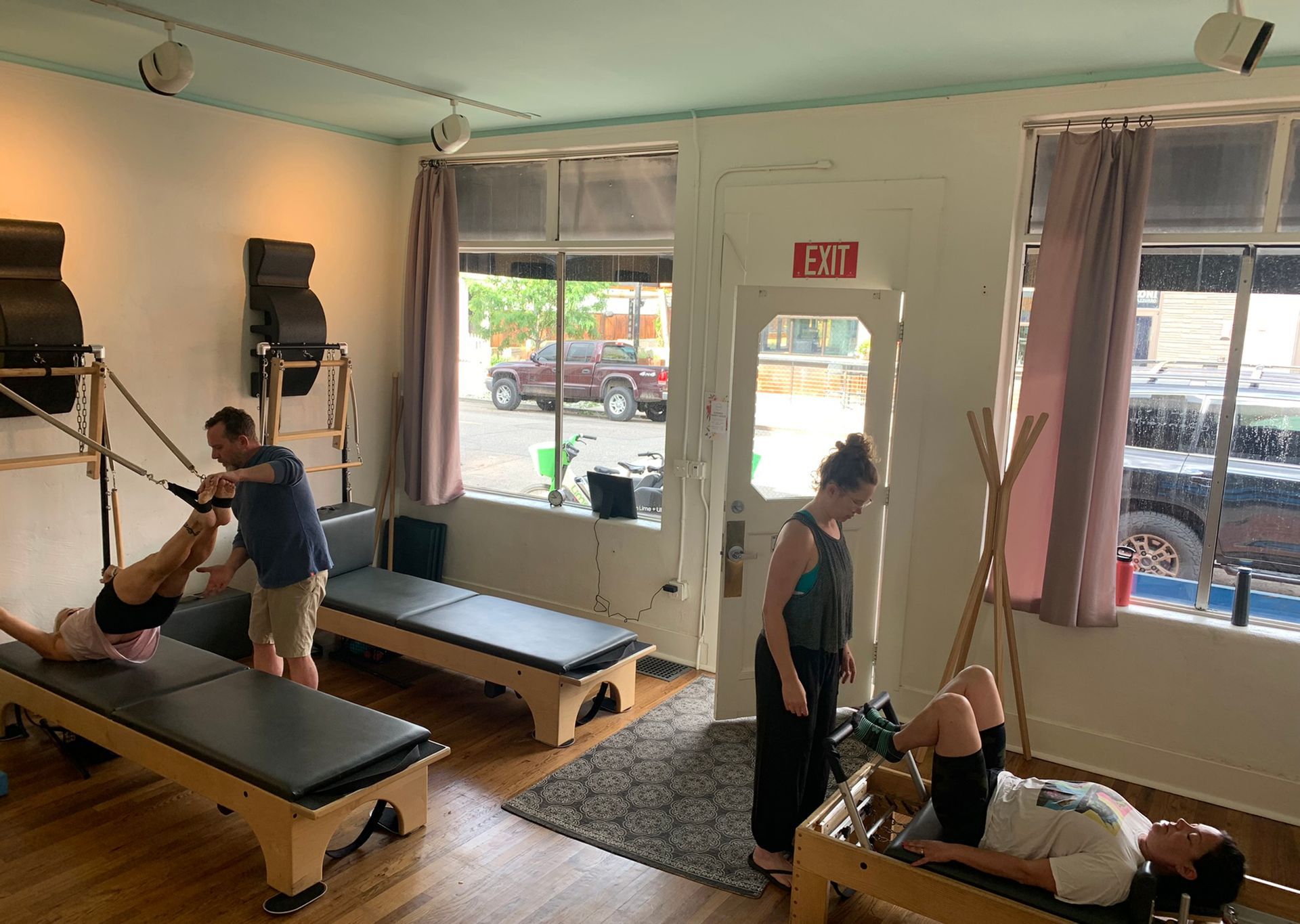 A group of people are doing pilates exercises in a gym.