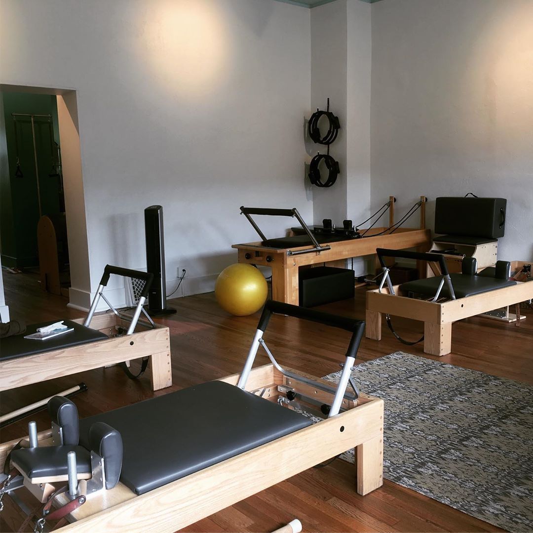 A room filled with pilates equipment and a yellow ball