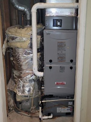 An air conditioner is sitting in a closet next to a wall.