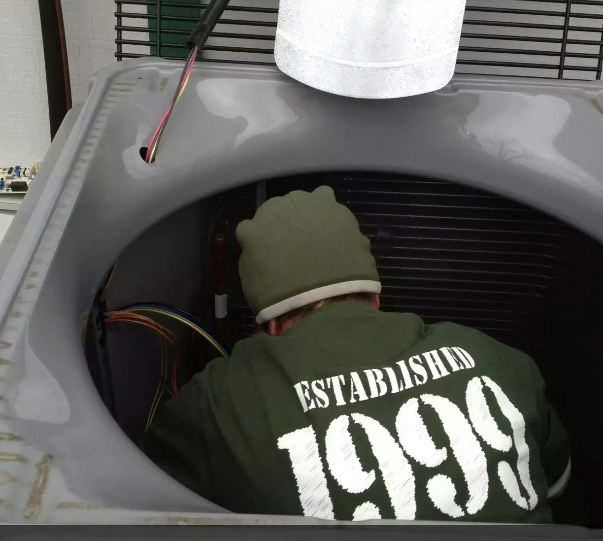 A man wearing a green sweatshirt that says established 1999