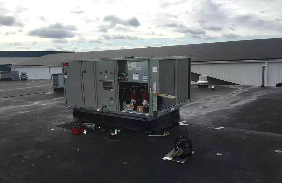 A large air conditioner is sitting on top of a roof.