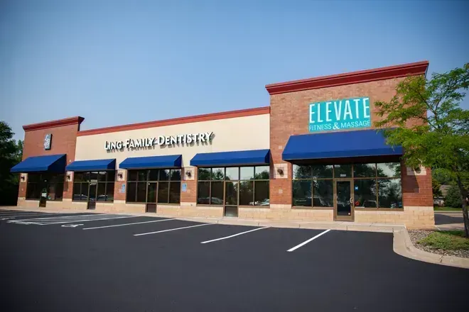 Restaurant interior with tables, chairs, pendant lights, and decorative wavy wall.