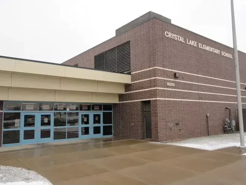 Crystal Lake Elementary School exterior, brown brick building, blue door, overcast sky.