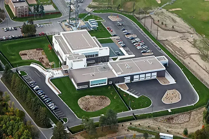 Aerial view of a modern, multi-building structure with extensive parking and green spaces.