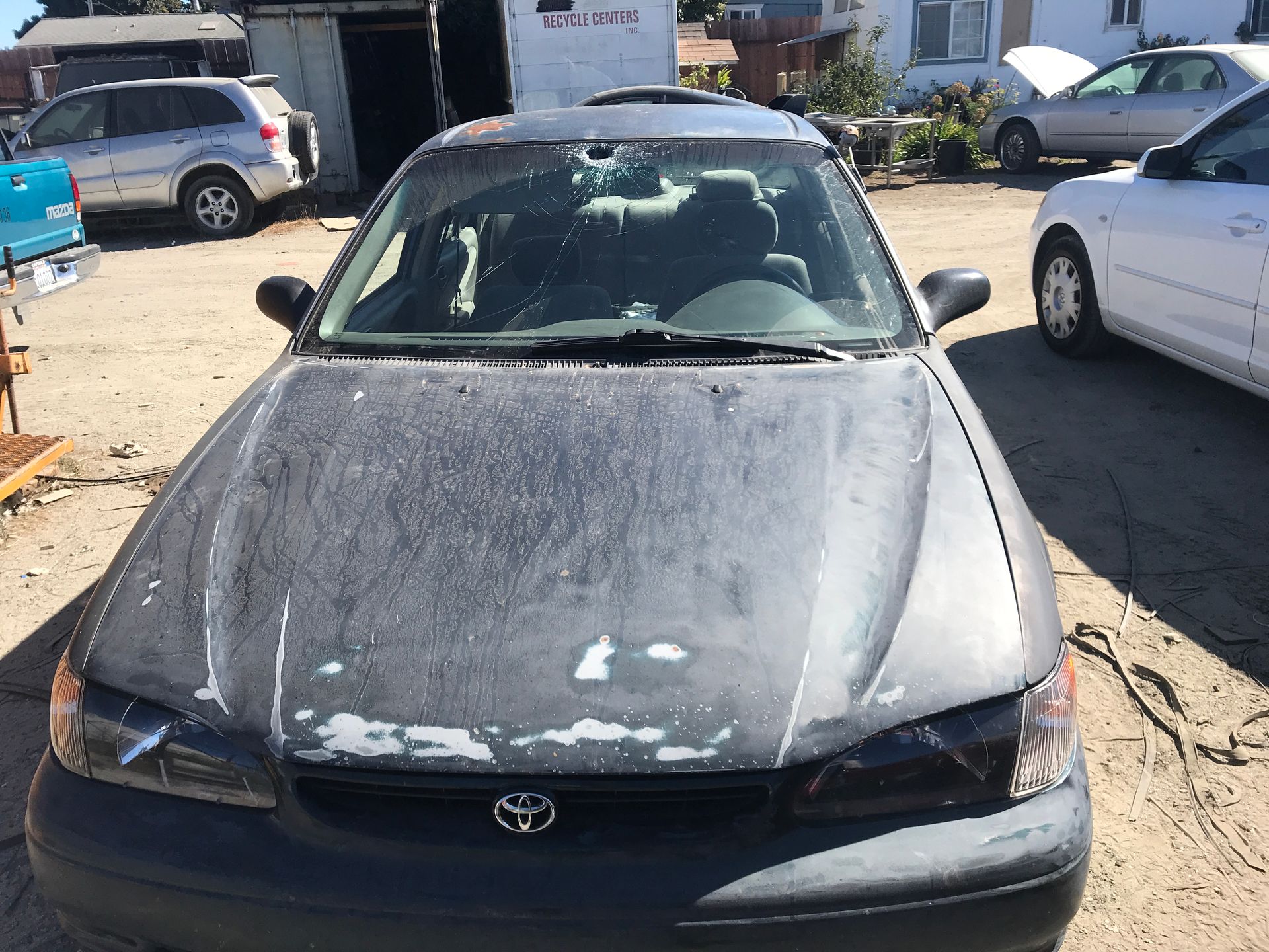 Dark gray Toyota Tercel with faded paint, parked outdoors.