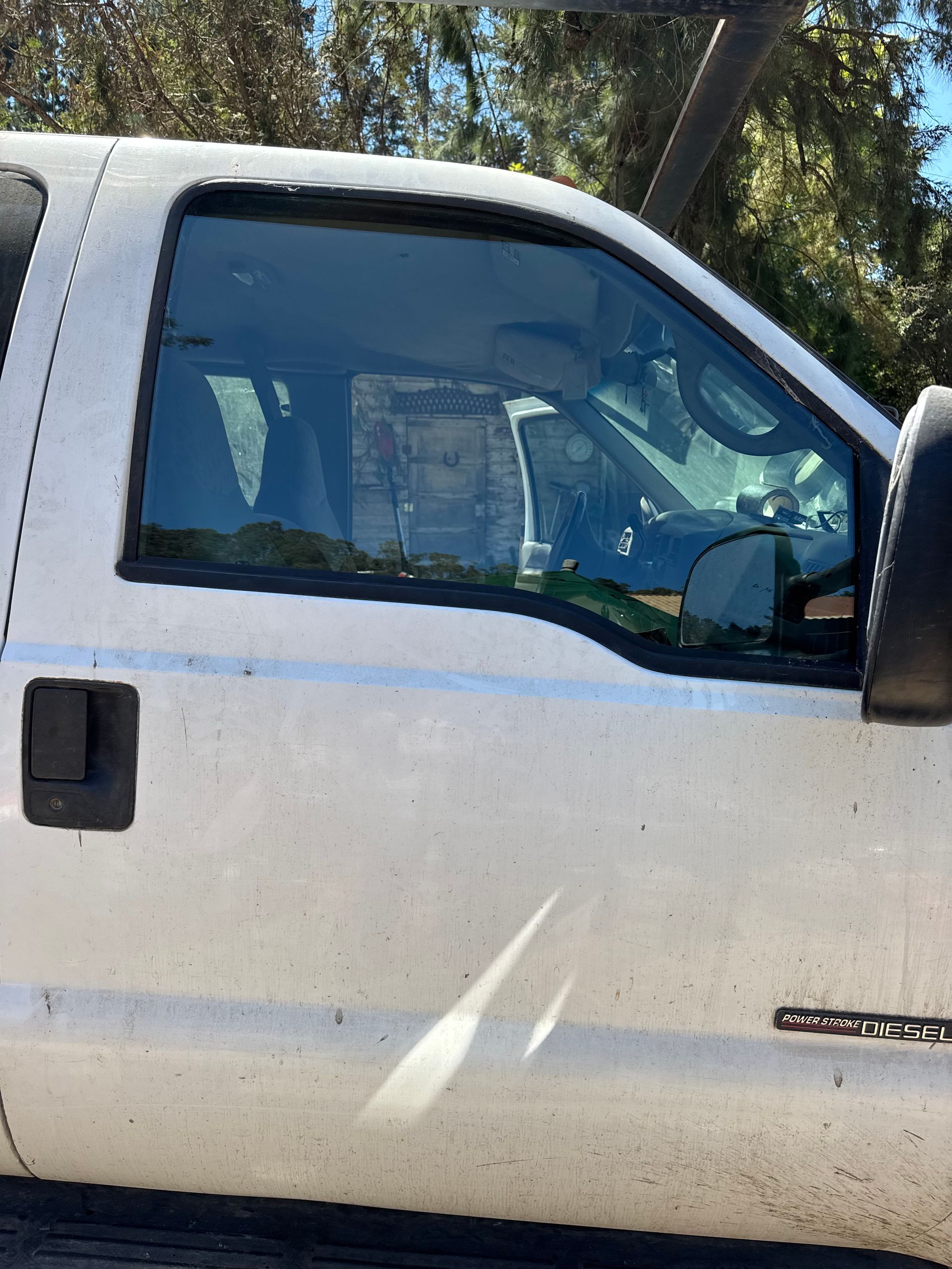 White pickup truck, side view, tinted windows, black door handle, outdoor setting.