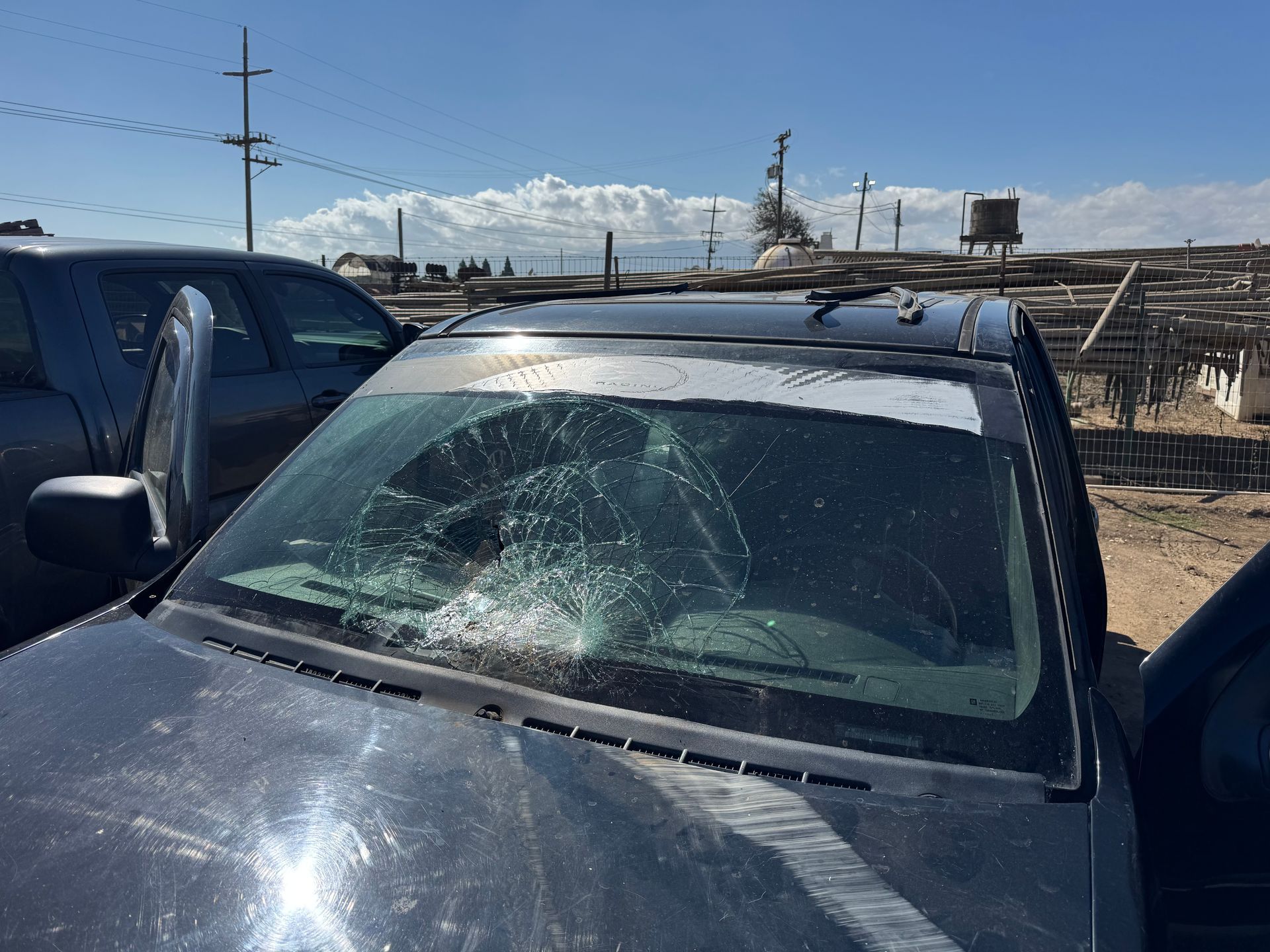 A car with a shattered windshield, parked outside.