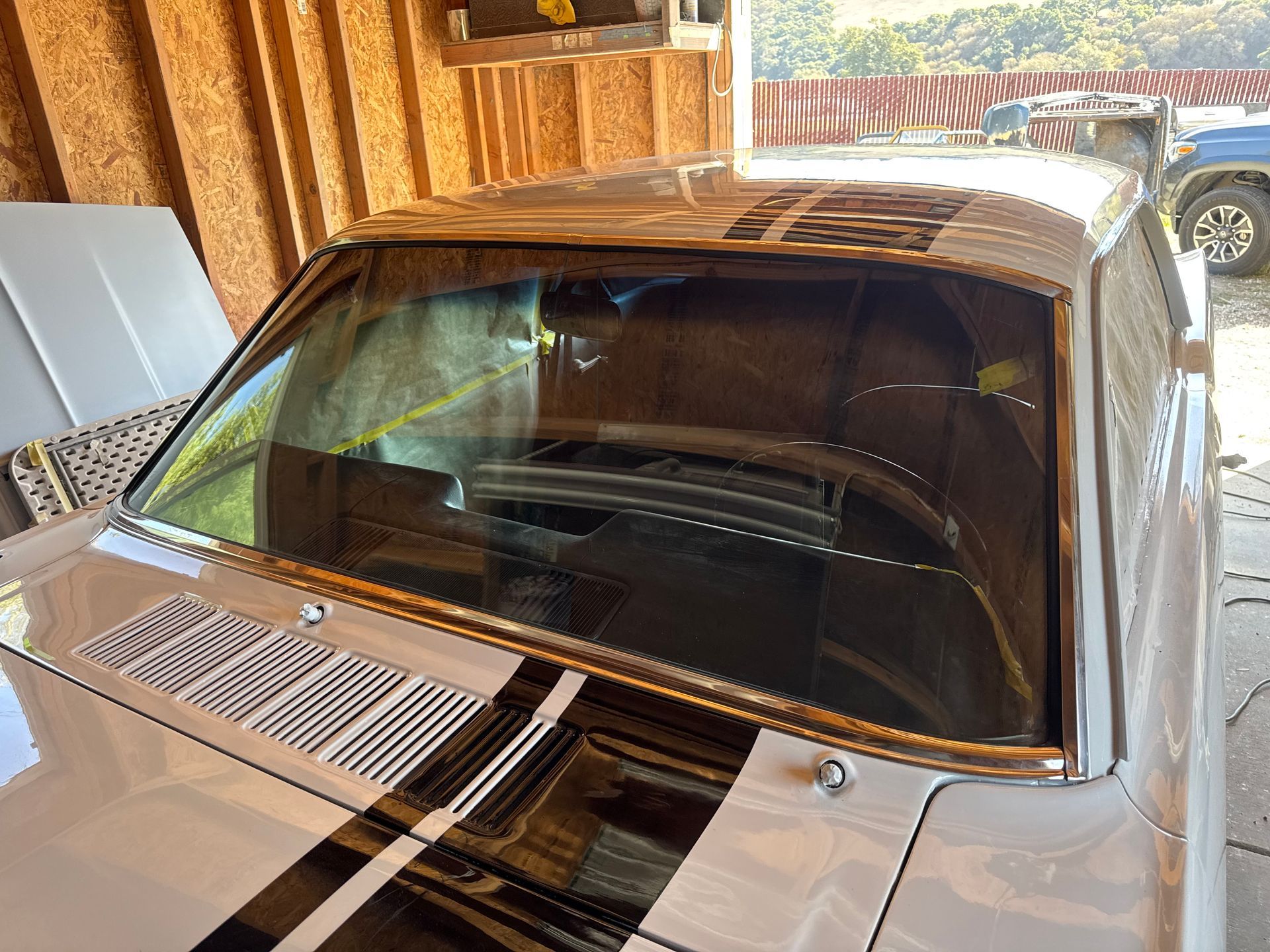 White classic car with black racing stripes and windshield.