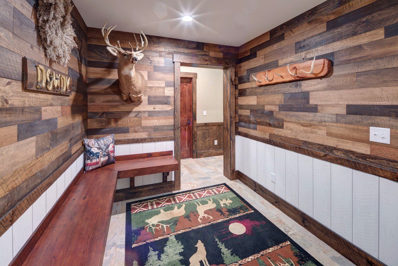 A hallway with wood paneling and a deer head on the wall.