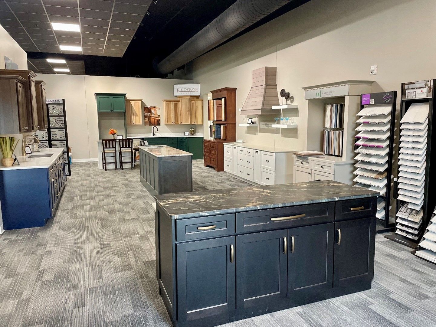 A kitchen showroom with a large island in the middle of the room.