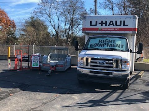 a white U-haul truck is parked in a parking lot