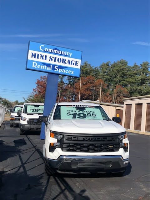 a white truck is parked in front of a community mini storage rental spaces sign