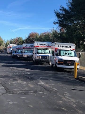 a row of U-haul trucks parked in a parking lot