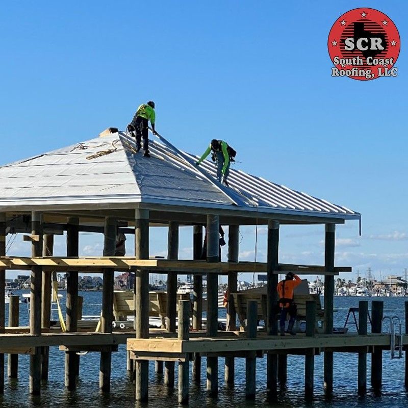 A sign for scr south carolina roofing shows two men working on a roof