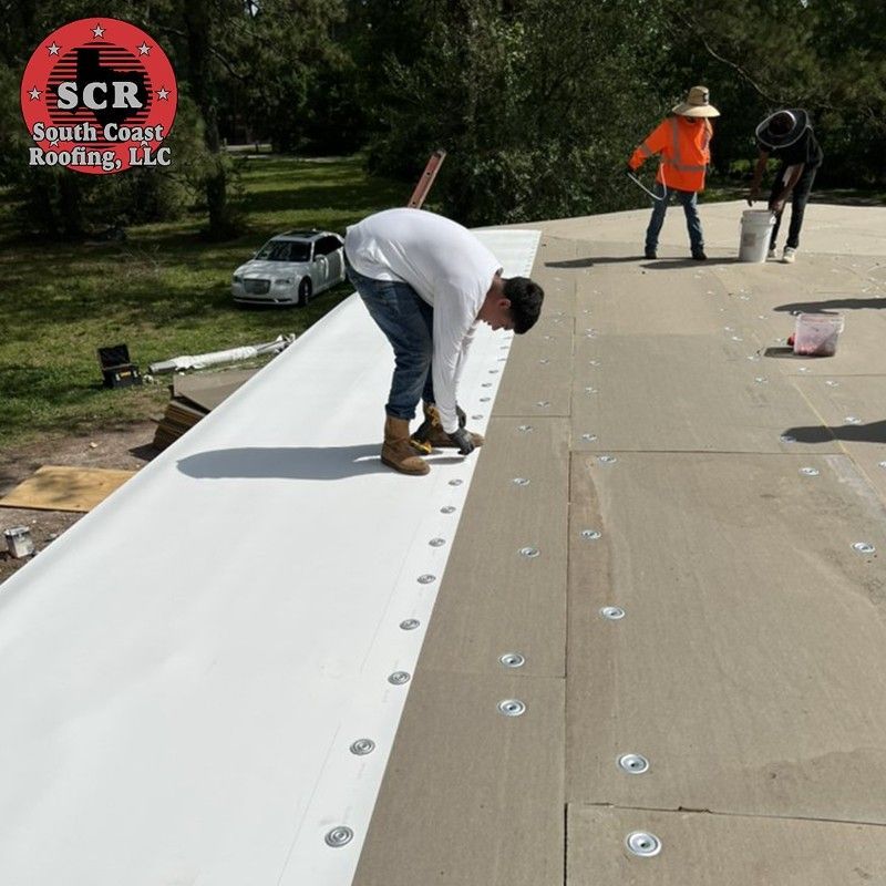 A man is working on a roof with scr roofing in the background