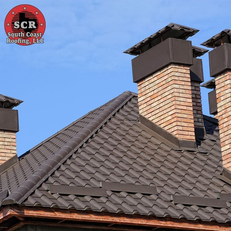 A roof with chimneys and a logo for scr south coast roofing llc
