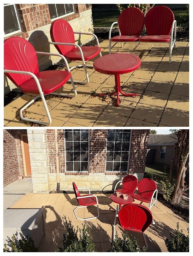 Red metal patio chairs and a table on a tan-colored patio.