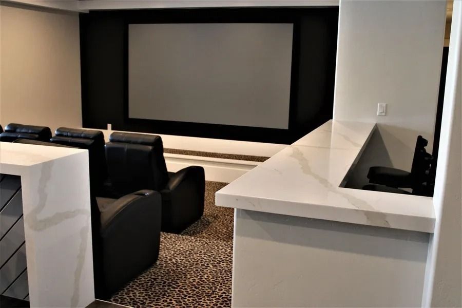Home theater with a screen, seating, and bar area.