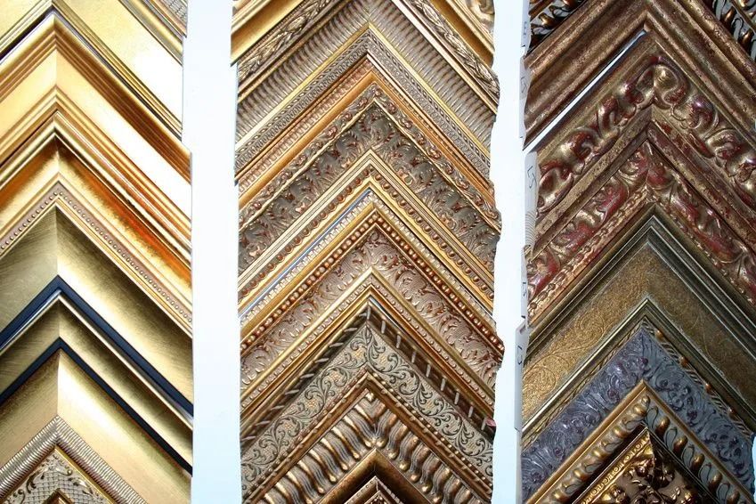 Rows of ornate gold, silver, and bronze picture frames with intricate decorative molding patterns