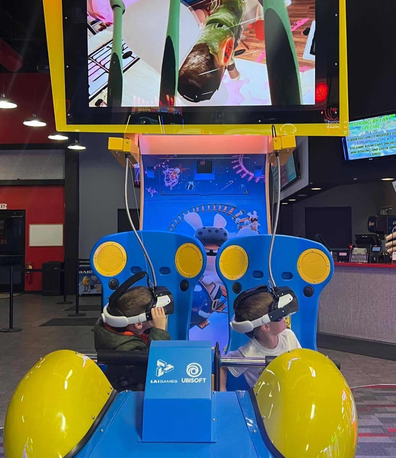 Blue arcade ride with yellow wheels and steering controls in a game center