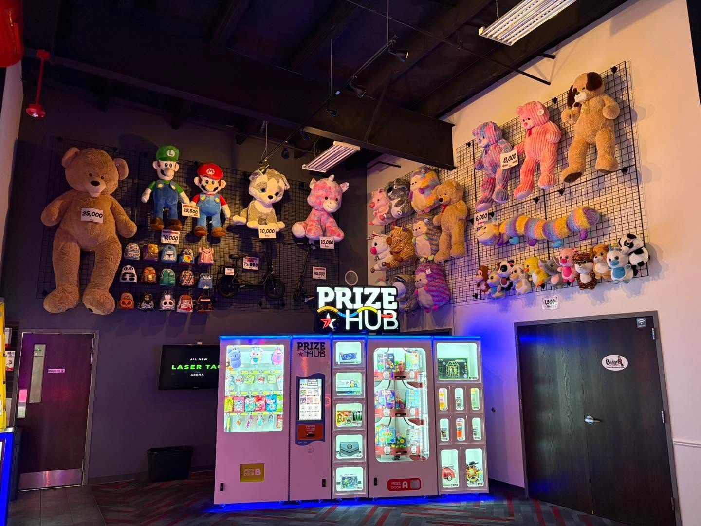 Prize Hub arcade with stuffed animal prizes, claw machines, and bright prize displays in a dark room
