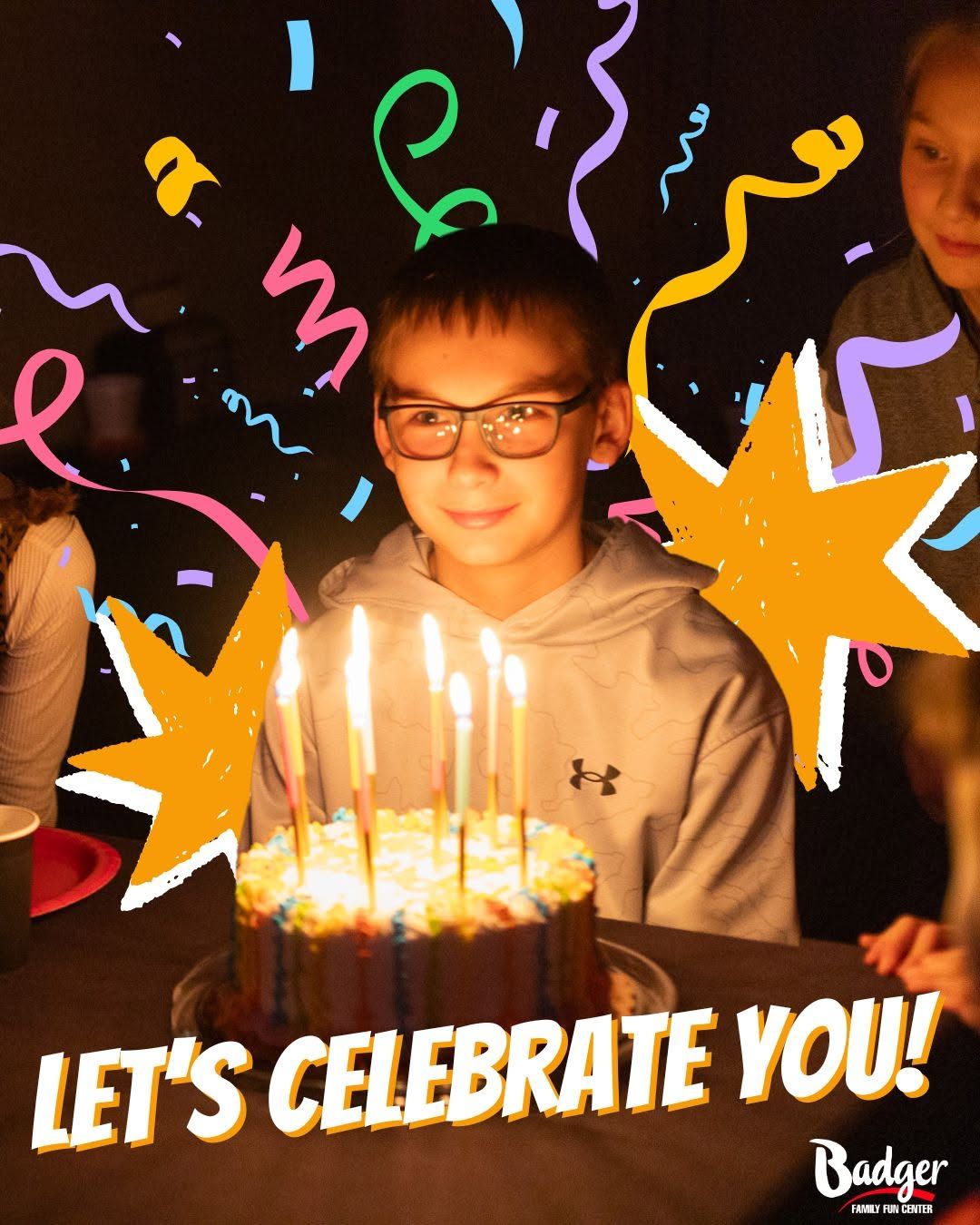 Child smiling behind birthday cake with lit candles, colorful confetti, and “LET’S CELEBRATE YOU!” text