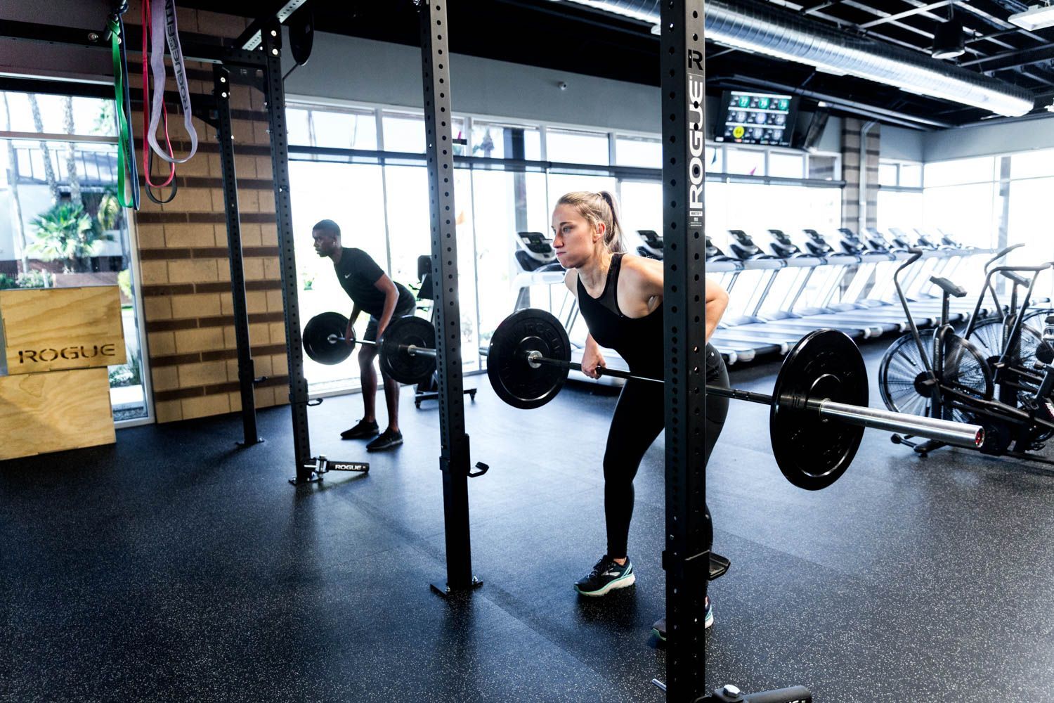 People lifting weights in a gym with exercise equipment.