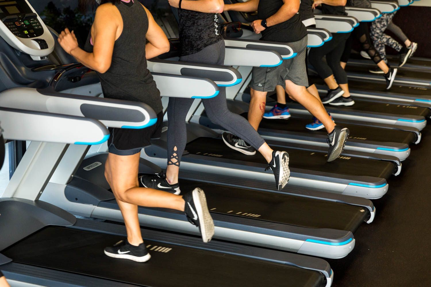 People running on treadmills in a gym setting.