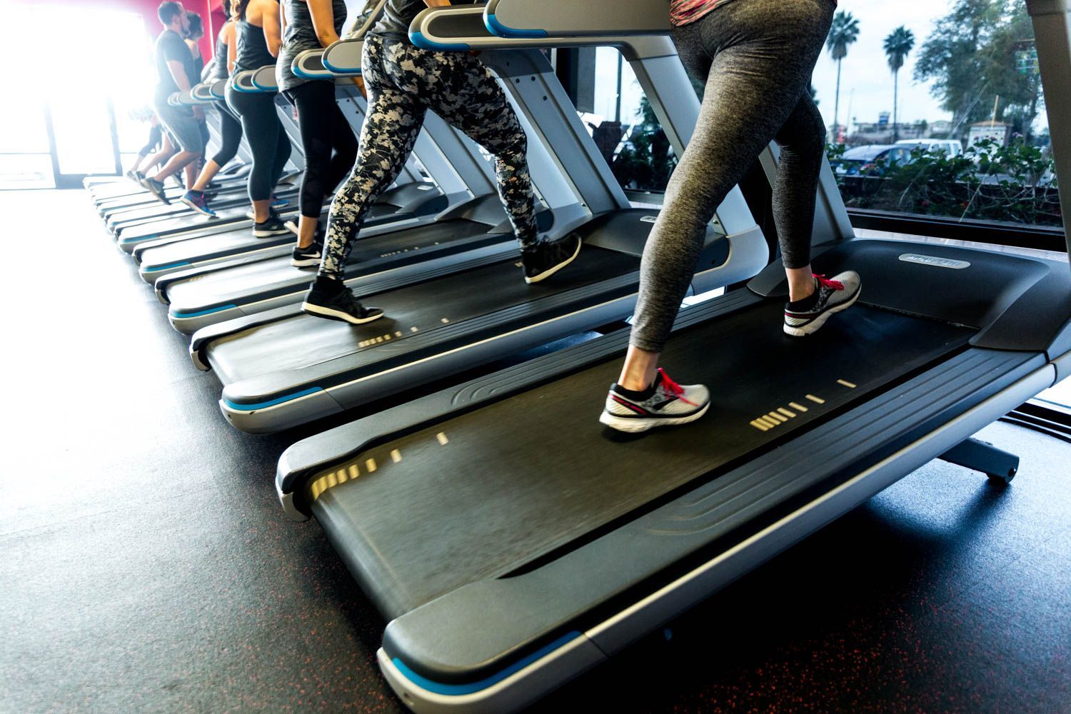 People running on treadmills at a gym.