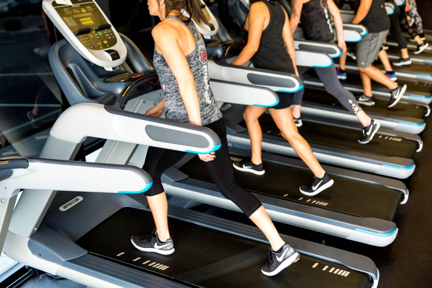 People running on treadmills in a gym setting.