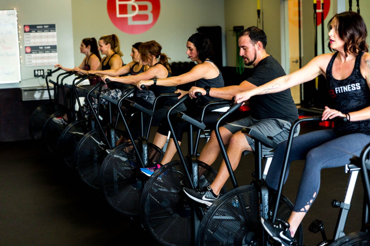 People working out on air bikes in a gym.