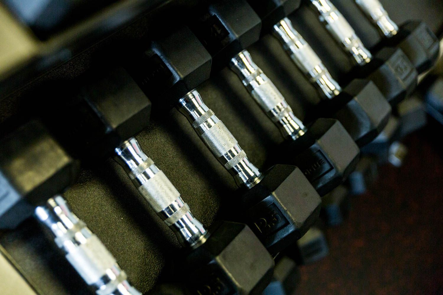 Dumbbells in a rack, close-up, black and silver.
