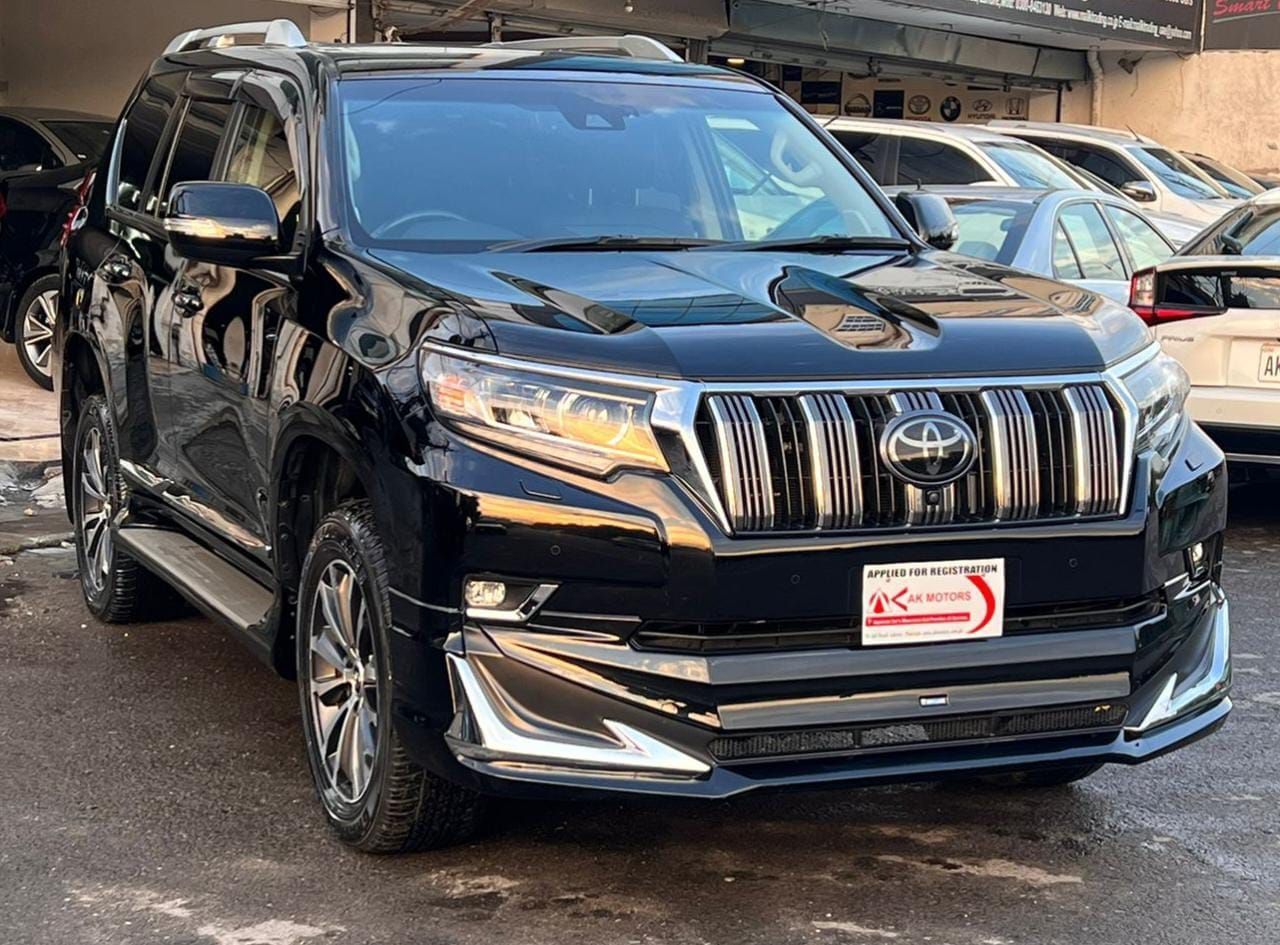 Black Toyota Land Cruiser Prado SUV parked outdoors, front view.