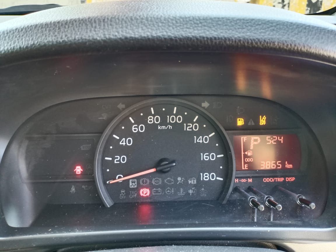 Car dashboard displaying speedometer, digital display, and warning lights.