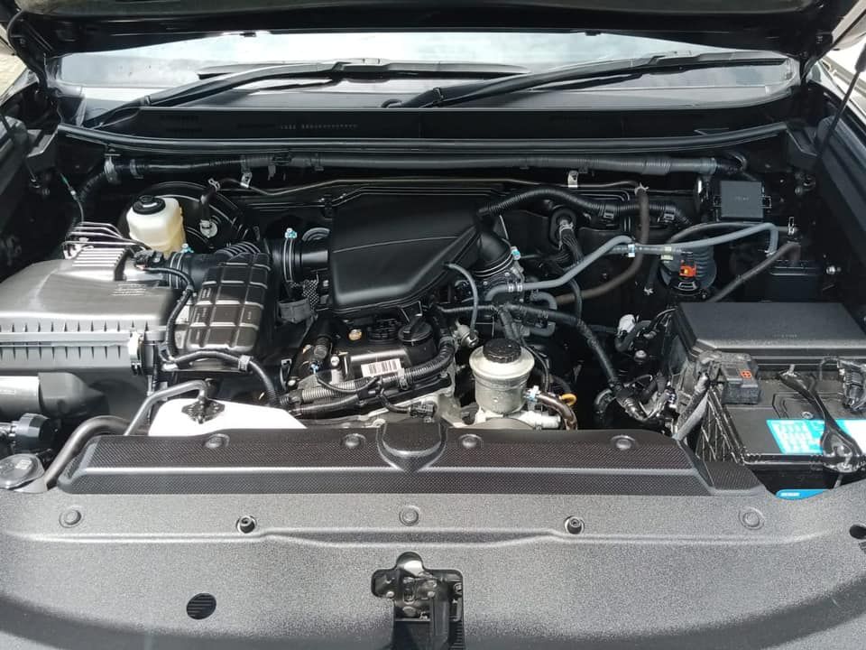 Black car engine bay with various components visible.