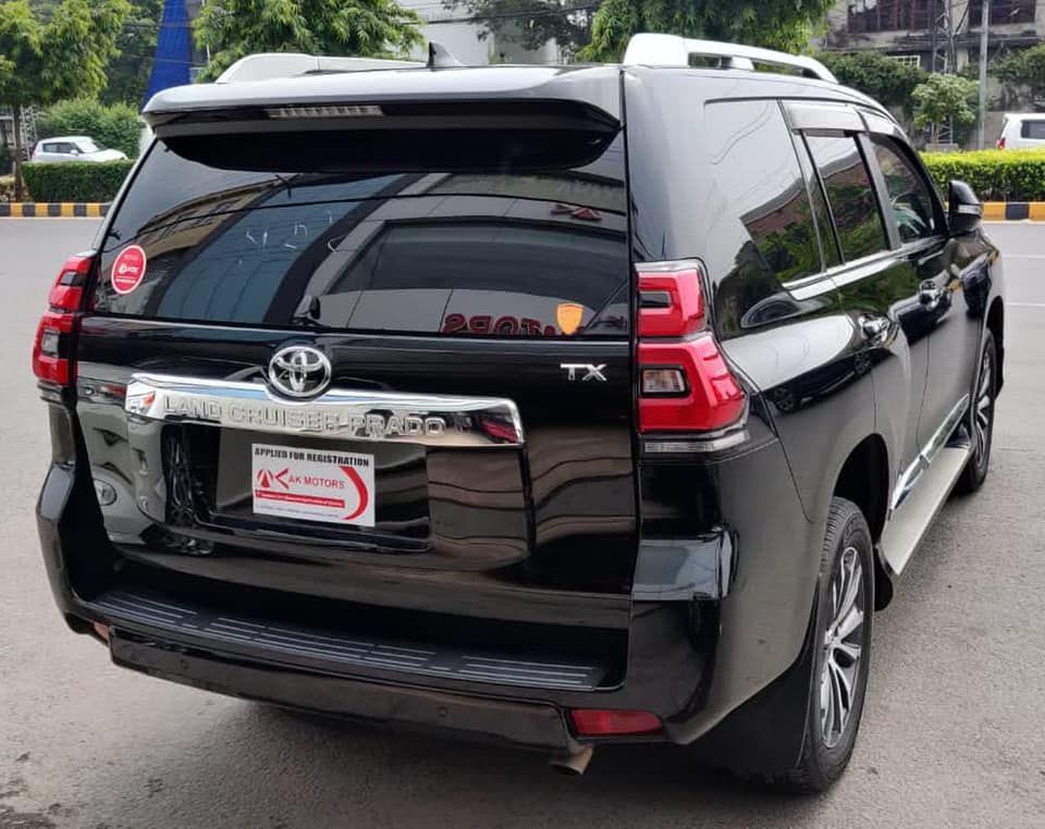 Black Toyota Land Cruiser Prado SUV, rear view, on a road.
