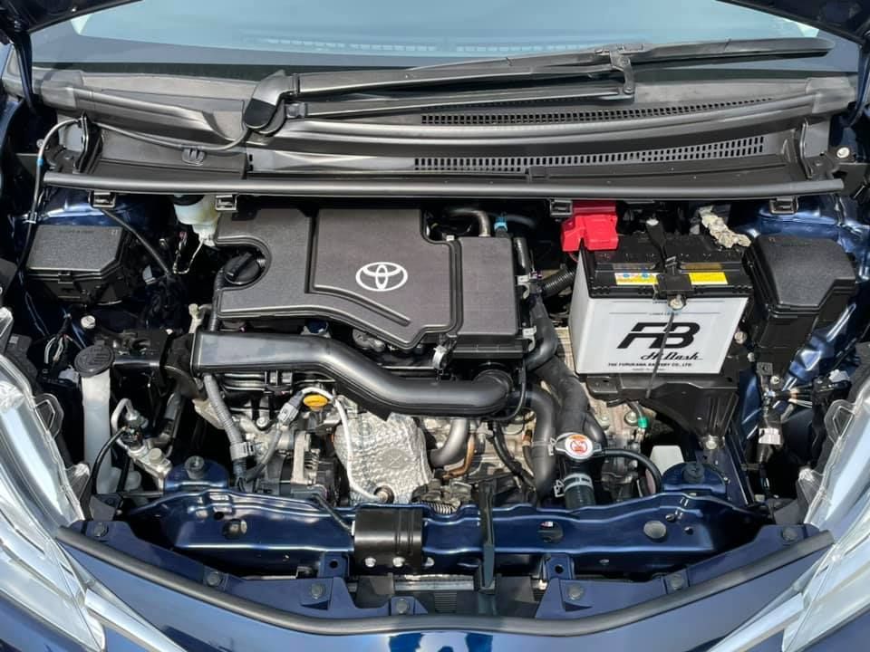 Blue car engine bay with a Toyota logo, battery, and various components.
