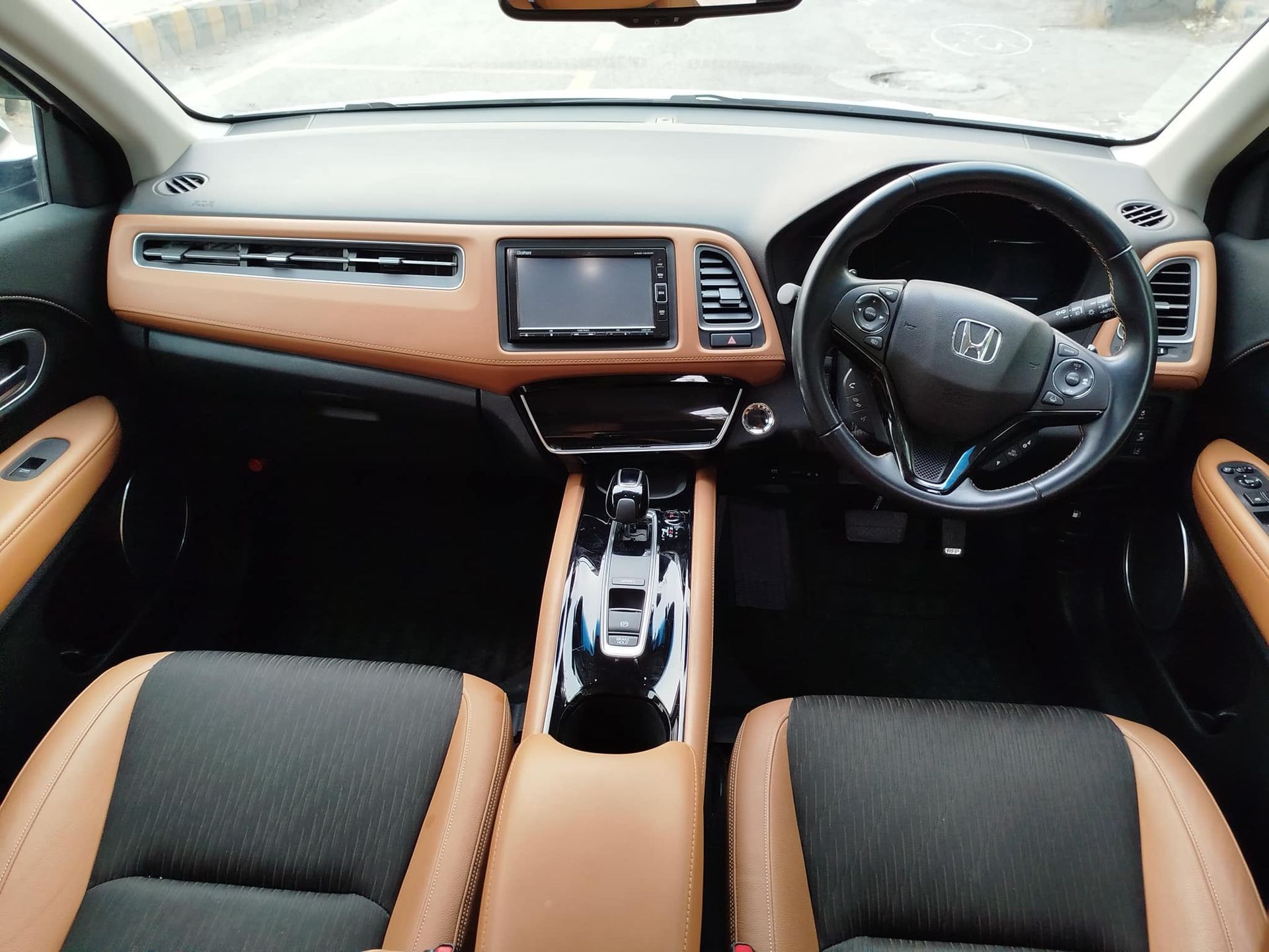Interior of a Honda HR-V with brown and black leather seats, dashboard and steering wheel.