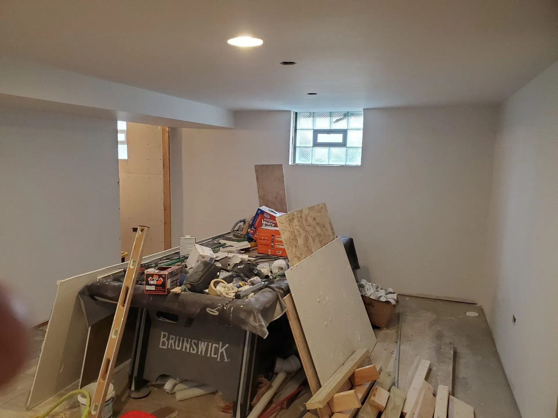 Basement under construction, drywall and debris piled up.