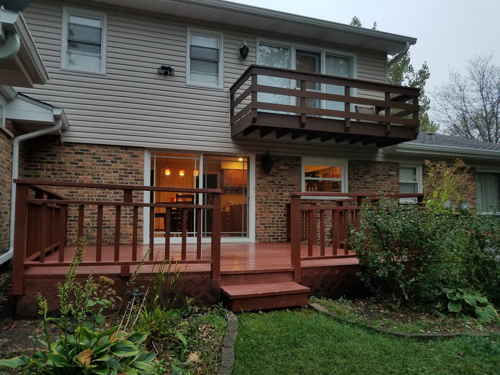 Two-story house with a wooden deck and balcony. 