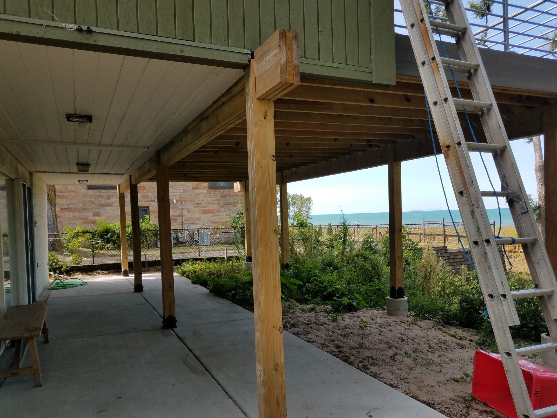 Under deck with wooden supports overlooking a body of water.