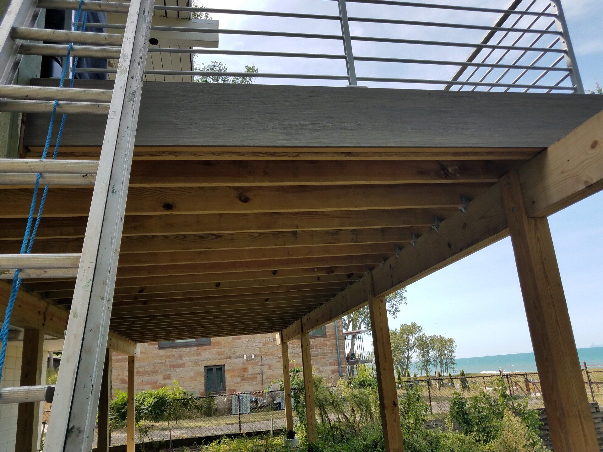 Wooden deck under construction with a ladder leaning against it. 