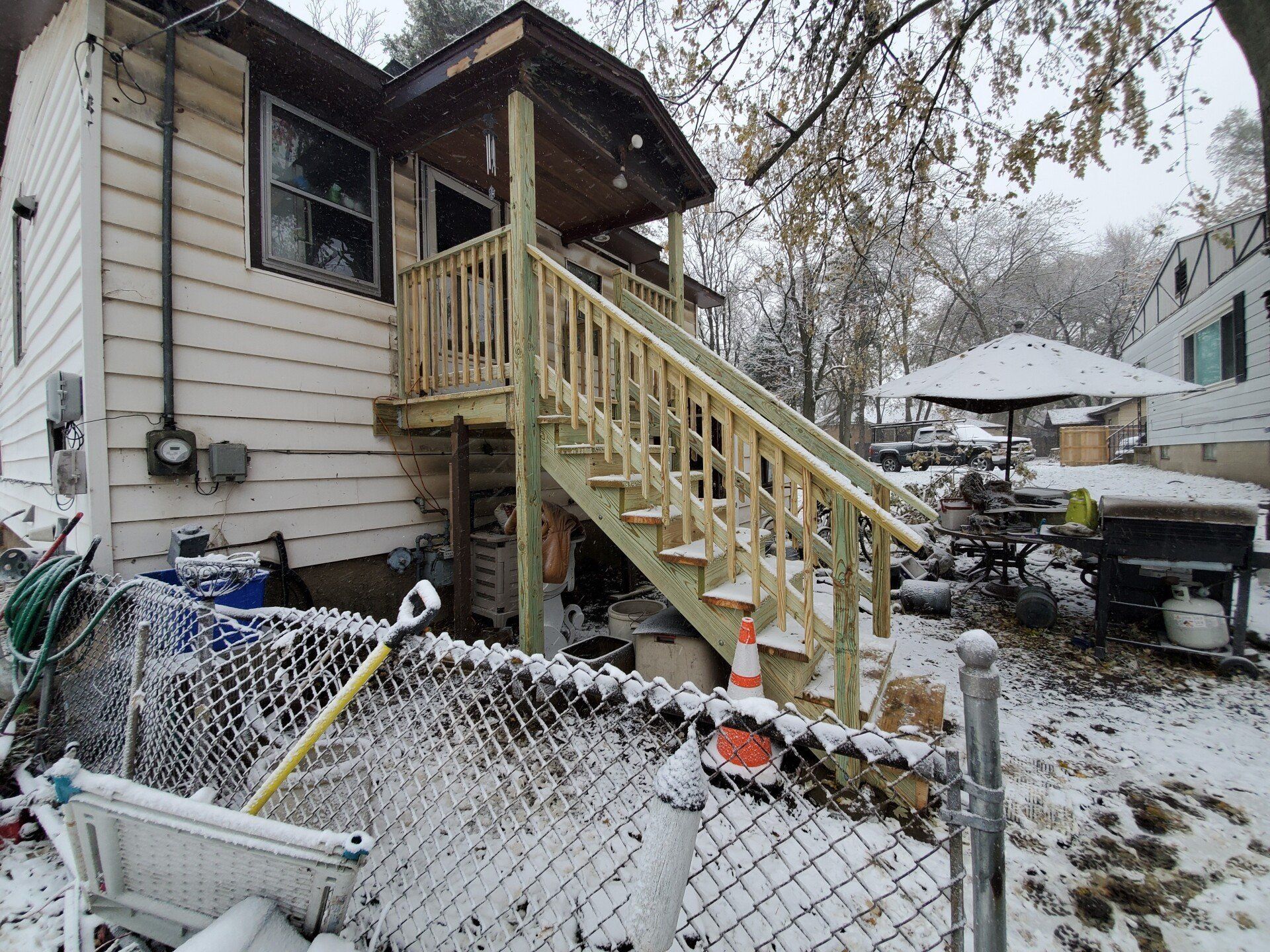 Newly constructed wooden stairs and porch on the side of a house.