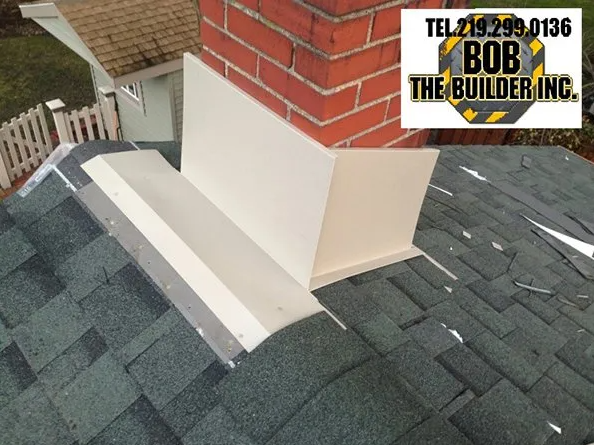 Chimney flashing on a roof, white metal. Brick chimney in the background. 