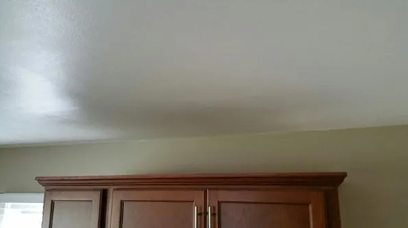 Brown wooden cabinets against tan and white walls.