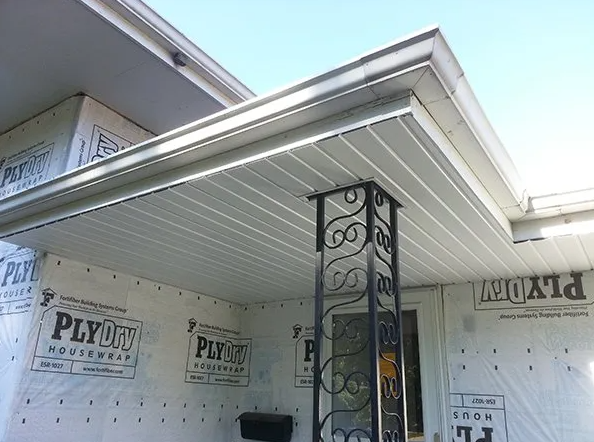 Exterior porch with white siding, soffit, and decorative black metal support post.