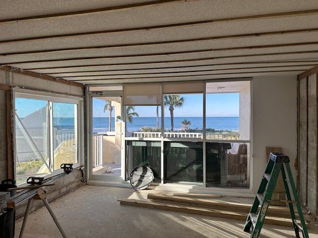 A room with a ladder in it and a view of the ocean.